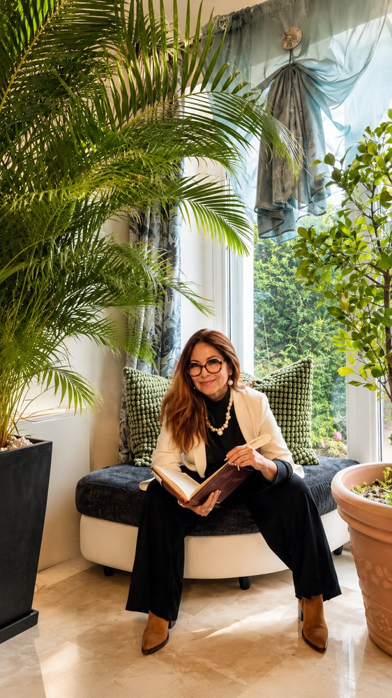 Angelica Solis, seduta tra palme con un libro